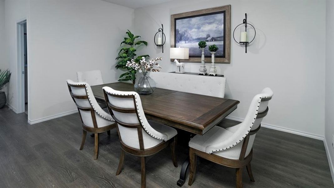 Dining area featuring dark wood-style flooring and baseboards