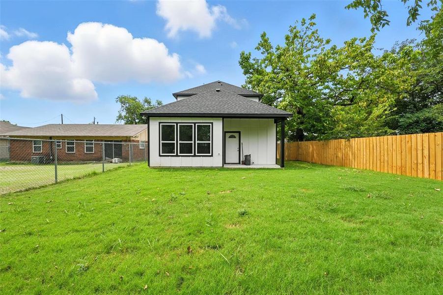 Back of property featuring a patio area, a fenced backyard, board and batten siding, and roof with shingles