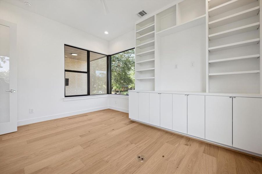 The ground floor study with large corner windows and built in book shelves.