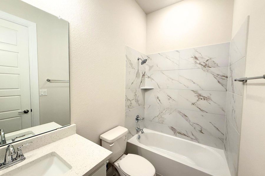 Modern elegance defines this bath with a sparkling tub, tiled shower surround, and a sleek vanity. Modern elegance defines this bath with a sparkling tub, tiled shower surround, and a sleek vanity.