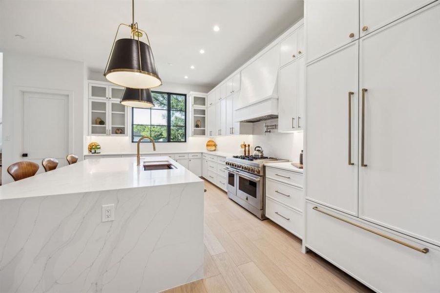 Chef's dream kitchen with waterfall quartz countertops, high end appliances and wood flooring. Chef's dream kitchen with waterfall quartz countertops, high end appliances and wood flooring.