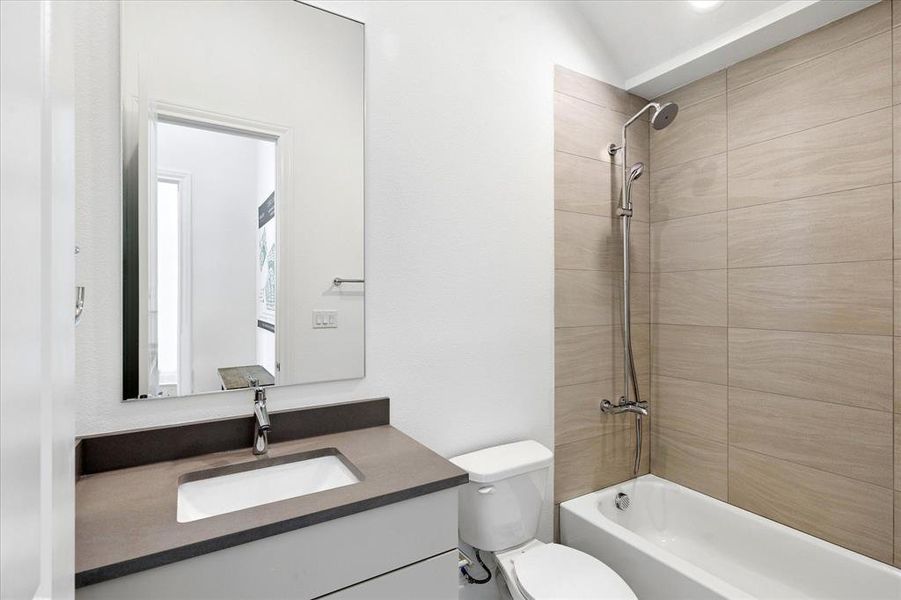Contemporary bathroom featuring a floating vanity with an integrated sink and dark countertop