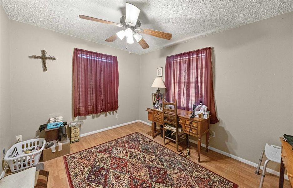 Office with ceiling fan, wood finished floors, and a textured ceiling