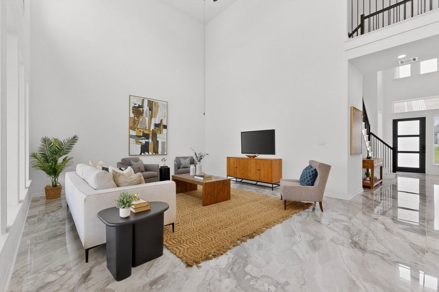 Spacious living area featuring high ceilings, large format tile flooring, and abundant natural light from multiple windows