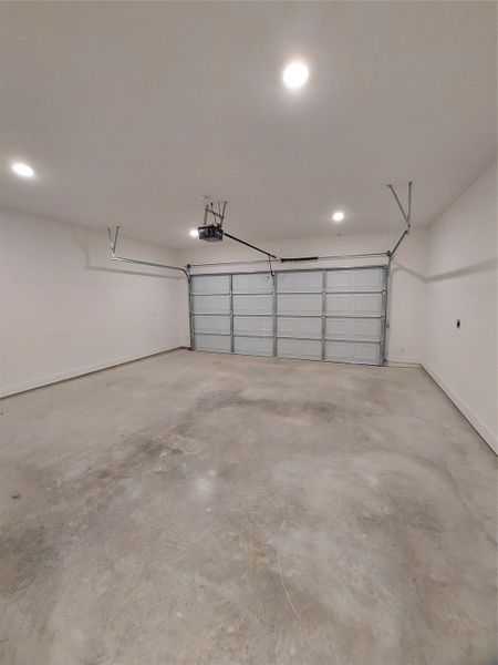 A View of the Garage with Baseboards and Recessed Lighting in the garage as well.