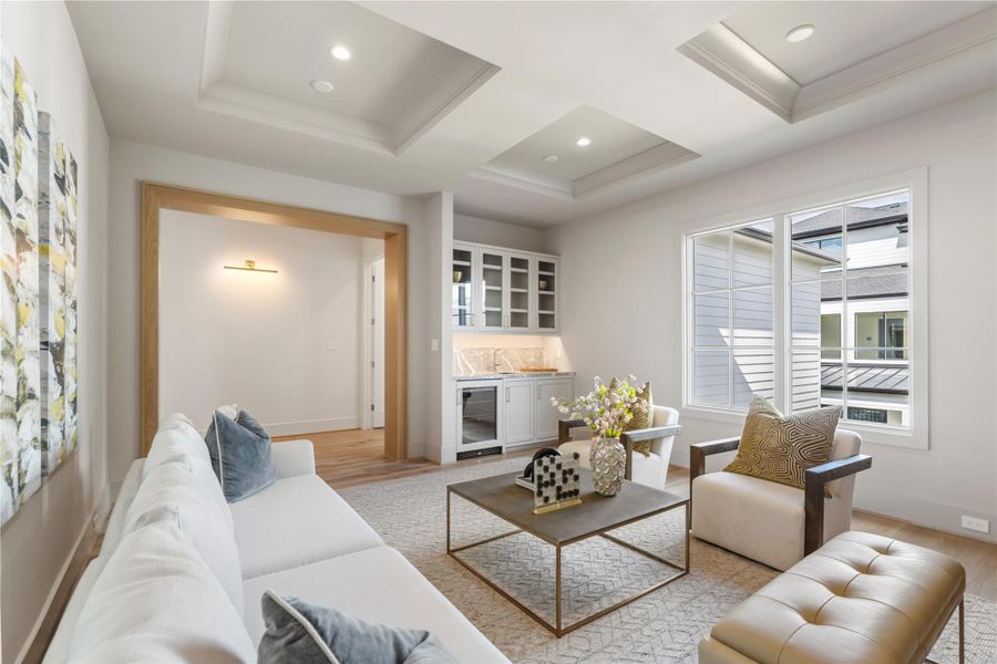 The magnificent media room is adorned with a quartet of tray cutouts in the ceiling for a regal, unique appearance. The wet bar is accented with gray marble countertops and a sea of shelving for your glassware. A beverage cooler is great for sodas and wine without having to go downstairs!