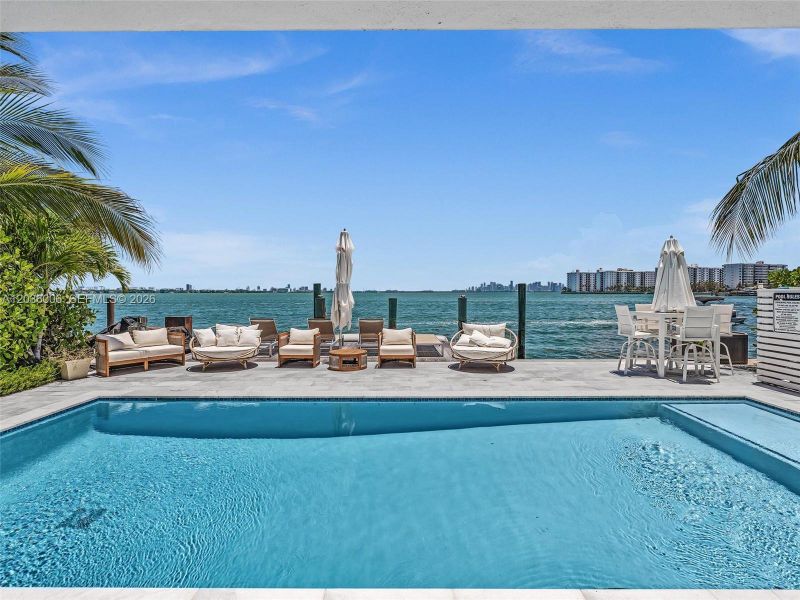 Pool with outdoor furniture with Direct Bay Views.