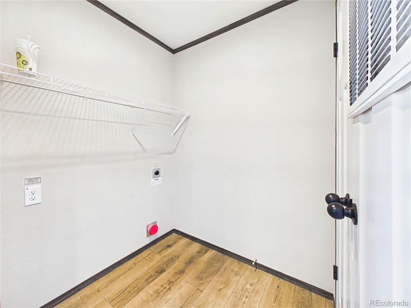 Laundry Area – Functional laundry space with shelving and room for appliances, designed for everyday convenience.