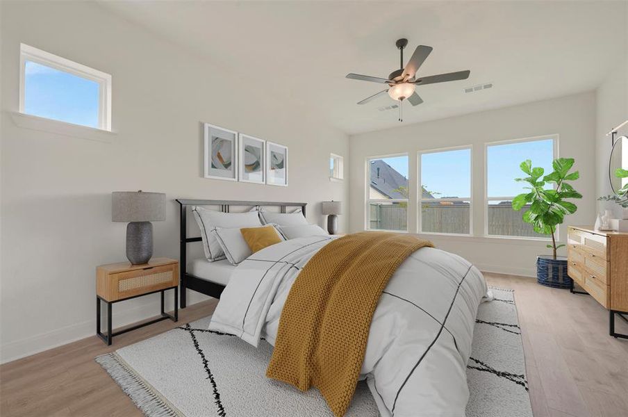 Light-filled bedroom featuring wood-finish flooring, a ceiling fan, and multiple windows