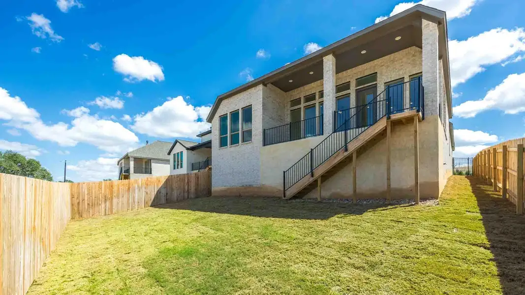 Rear view of property featuring stairs, a fenced backyard, a balcony, and brick siding Rear view of property featuring stairs, a fenced backyard, a balcony, and brick siding