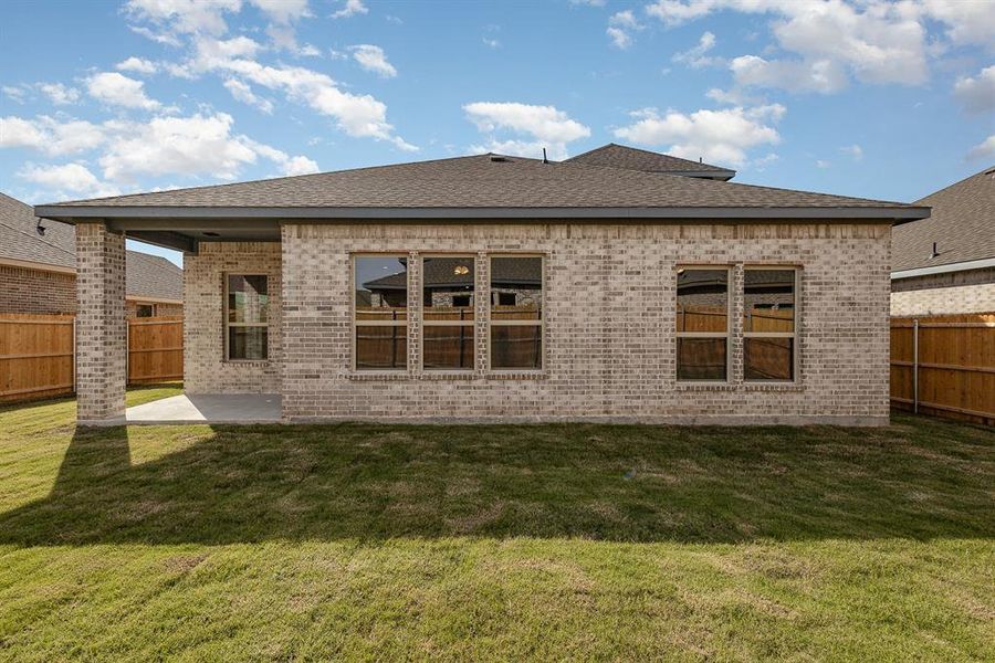 Rear view of property with a yard and a patio