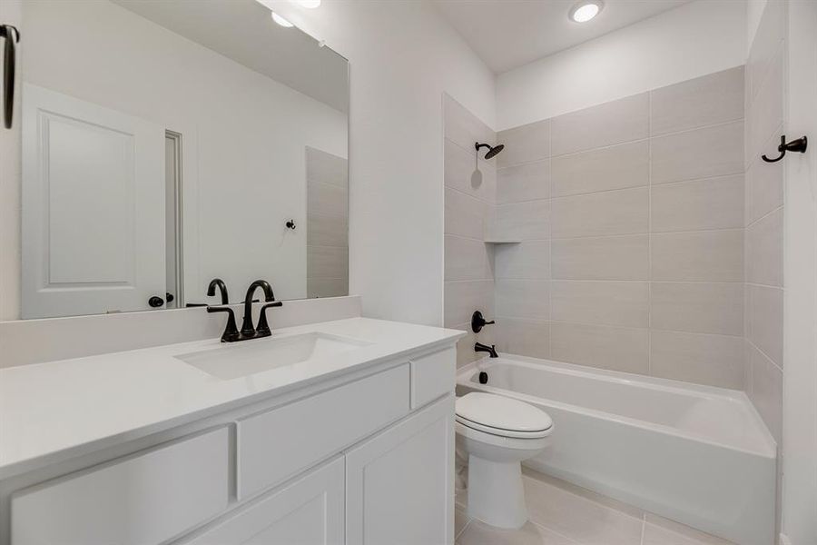 Full bathroom with tub / shower combination, vanity, and light tile patterned floors Full bathroom with tub / shower combination, vanity, and light tile patterned floors