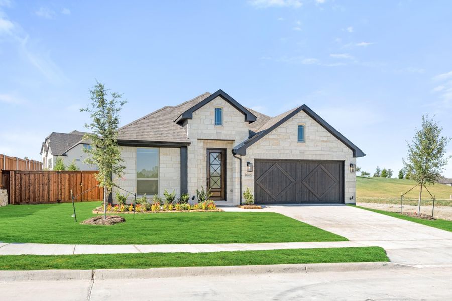 Single-story home with light stone exterior, two-car garage, and landscaped front yard