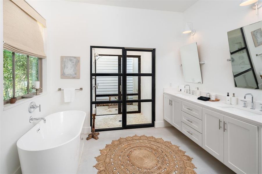 Bathroom featuring vanity and a bathing tub Bathroom featuring vanity and a bathing tub