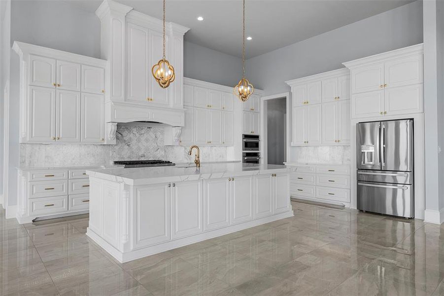 Kitchen featuring stainless steel appliances, backsplash, decorative light fixtures, white cabinetry, and recessed lighting Kitchen featuring stainless steel appliances, backsplash, decorative light fixtures, white cabinetry, and recessed lighting