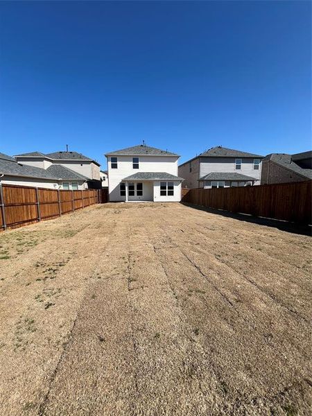 Back of property featuring a yard and a fenced backyard