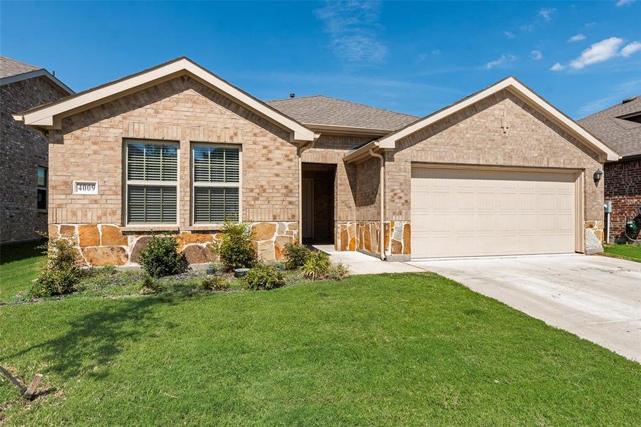 Ranch-style home featuring concrete driveway, a front lawn, brick siding, an attached garage, and roof with shingles Ranch-style home featuring concrete driveway, a front lawn, brick siding, an attached garage, and roof with shingles