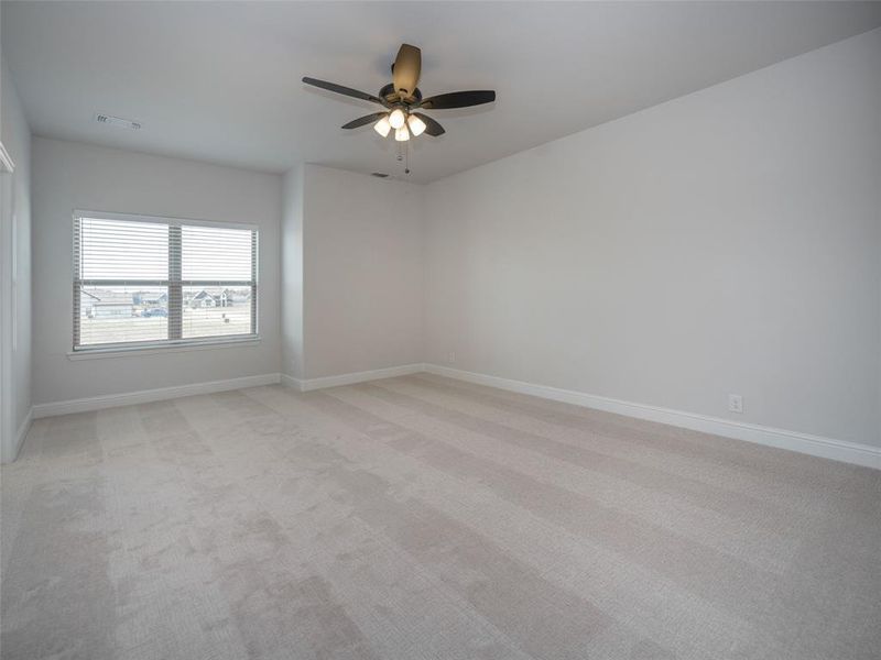 Unfurnished room with light colored carpet and ceiling fan Unfurnished room with light colored carpet and ceiling fan