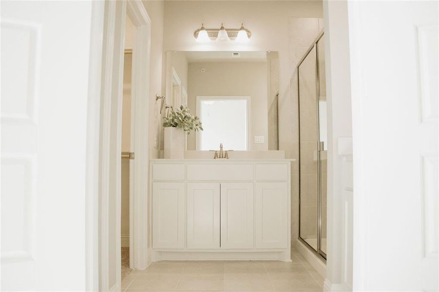 Bathroom featuring vanity, tile patterned floors, and walk in shower