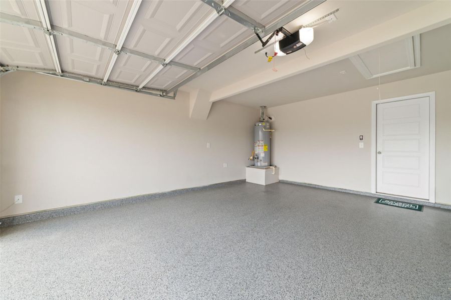 Spacious garage with clean epoxy-style flooring and ample room for parking and storage.