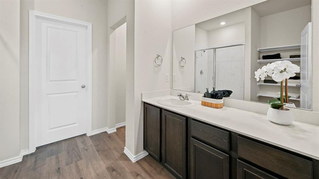Full bathroom featuring vanity, a stall shower, and dark wood-type flooring