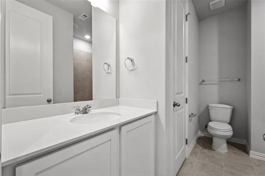 Full bath featuring light tile patterned floors and vanity