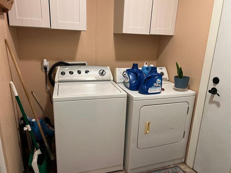 Washroom with washer and dryer and cabinets