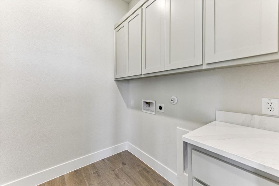 Laundry room featuring light wood-style floors, washer hookup, cabinet space, hookup for an electric dryer, and hookup for a gas dryer Laundry room featuring light wood-style floors, washer hookup, cabinet space, hookup for an electric dryer, and hookup for a gas dryer