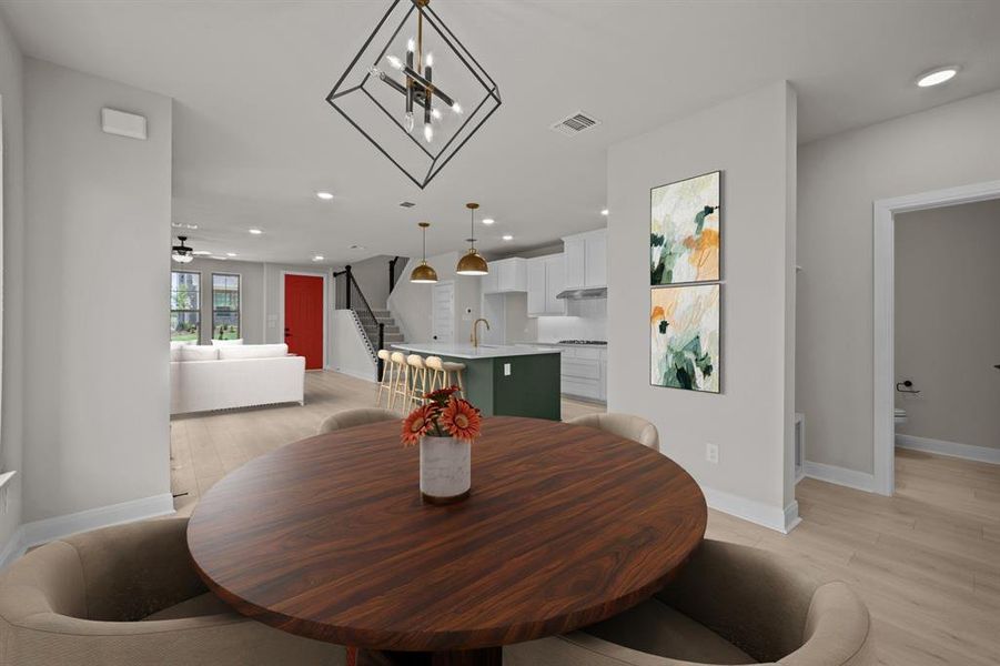 Dining room featuring light wood-style flooring, hanging lights, and a ceiling fan