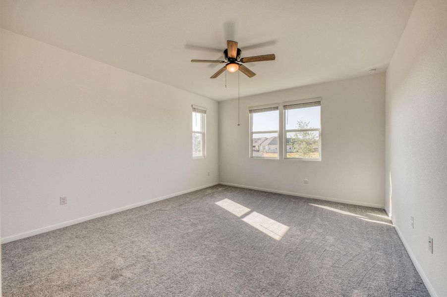 Generous natural light streams across the neutral carpeting of this versatile bedroom space.