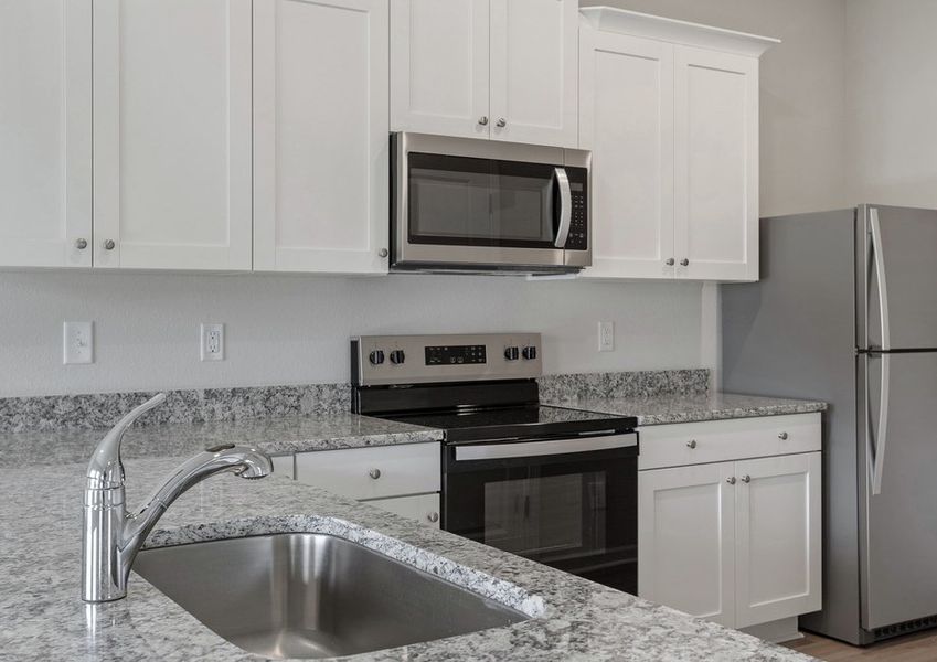 This kitchen comes with granite countertops and wood cabinets.