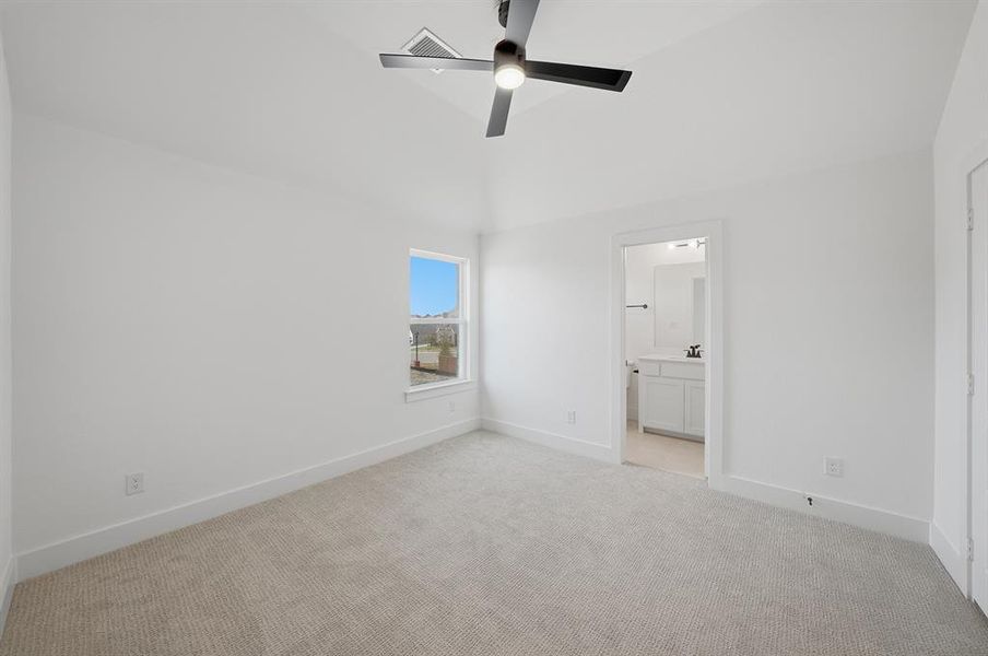 Unfurnished bedroom with light colored carpet, a ceiling fan, and ensuite bathroom Unfurnished bedroom with light colored carpet, a ceiling fan, and ensuite bathroom