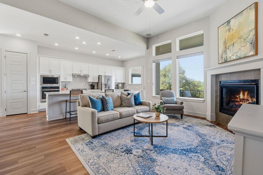 Living room with light wood-style floors, a tile fireplace, ceiling fan, and recessed lighting Living room with light wood-style floors, a tile fireplace, ceiling fan, and recessed lighting