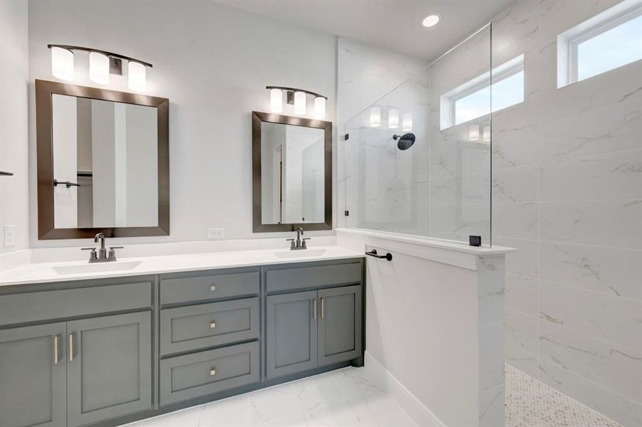 Bathroom featuring double vanity, a marble finish shower, and light marble finish flooring Bathroom featuring double vanity, a marble finish shower, and light marble finish flooring