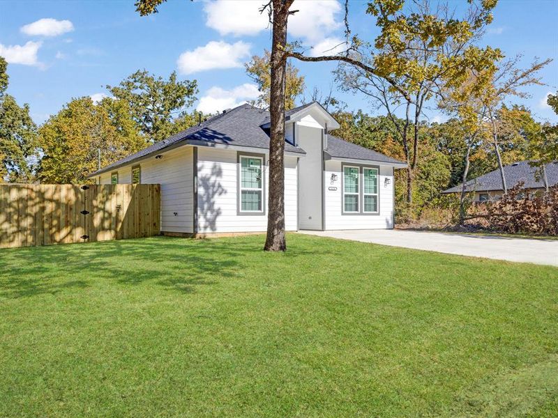 Ranch-style home with roof with shingles, a gate, and concrete driveway