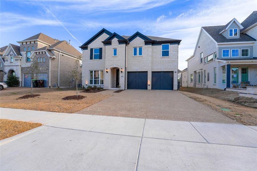 Traditional home featuring an attached garage, driveway, and brick siding