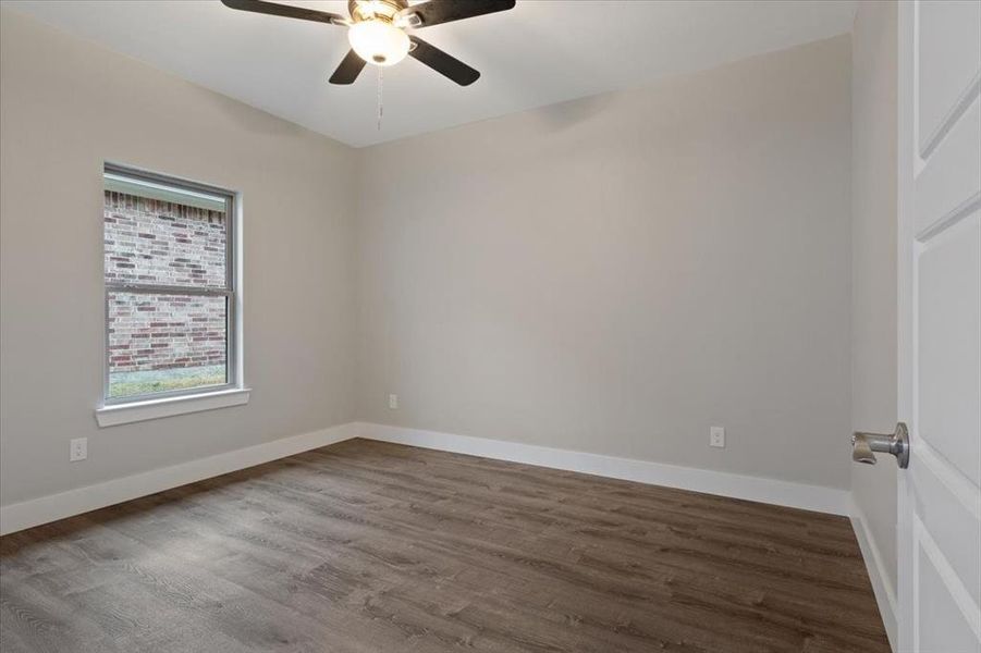 Empty room featuring hardwood / wood-style flooring and ceiling fan