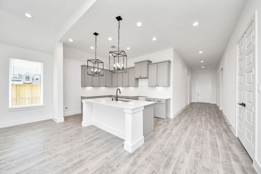 Step into a dream realized with this generously spacious kitchen! A massive granite island takes center stage, complemented by high ceilings and soft-close cabinets. The granite countertops, stainless steel appliances, sleek tile backsplash, and recessed lighting complete the elegant design. Step into a dream realized with this generously spacious kitchen! A massive granite island takes center stage, complemented by high ceilings and soft-close cabinets. The granite countertops, stainless steel appliances, sleek tile backsplash, and recessed lighting complete the elegant design.