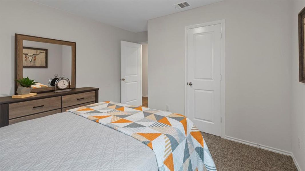 Bedroom with light colored carpet and baseboards