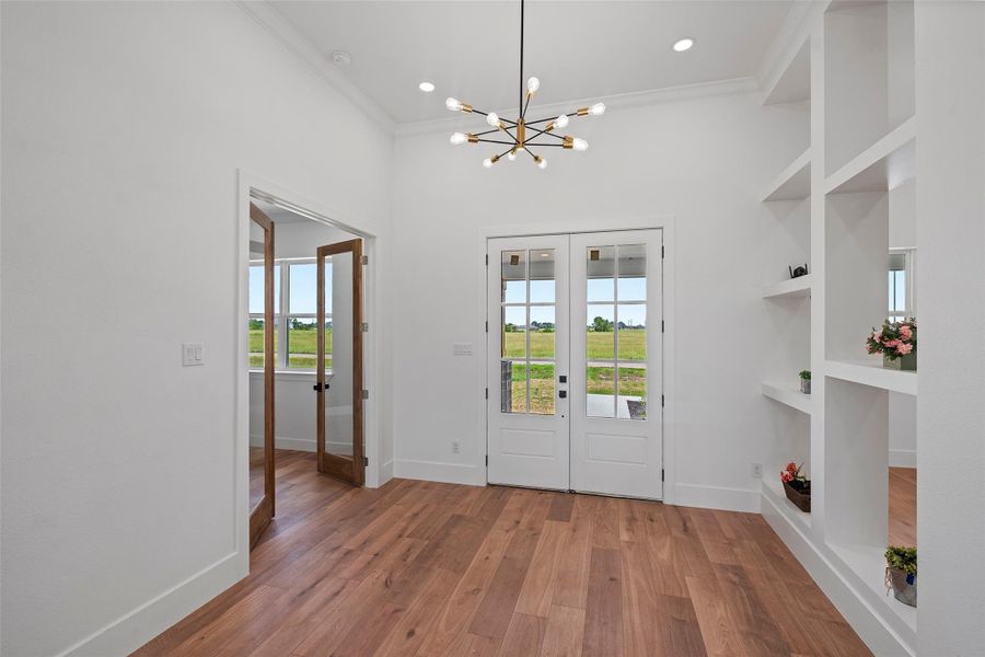 Welcome home to a bright and stylish foyer, featuring elegant LVP floors, modern lighting, and built-in shelves for a welcoming first impression.