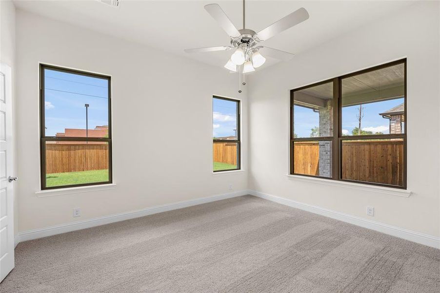 Carpeted spare room featuring healthy amount of natural light and ceiling fan Carpeted spare room featuring healthy amount of natural light and ceiling fan