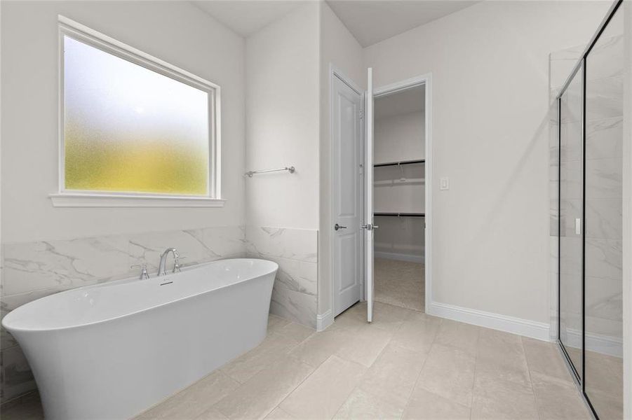 Bathroom featuring plus walk in shower, tile walls, and tile patterned floors