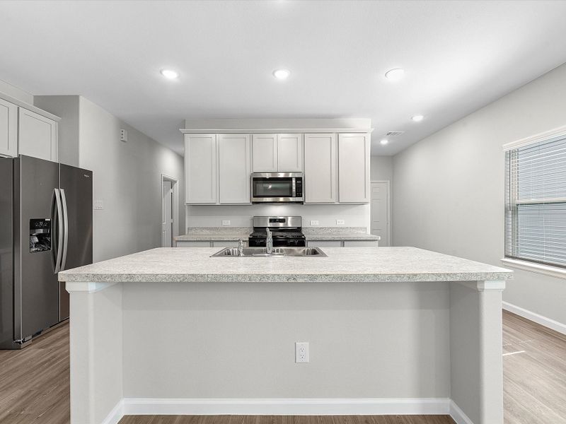 A kitchen with white cabinets.