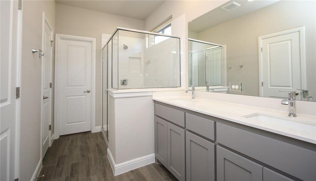 Master bath with double sink, water closet, large linen and towel closet, and walk-in clothes closet