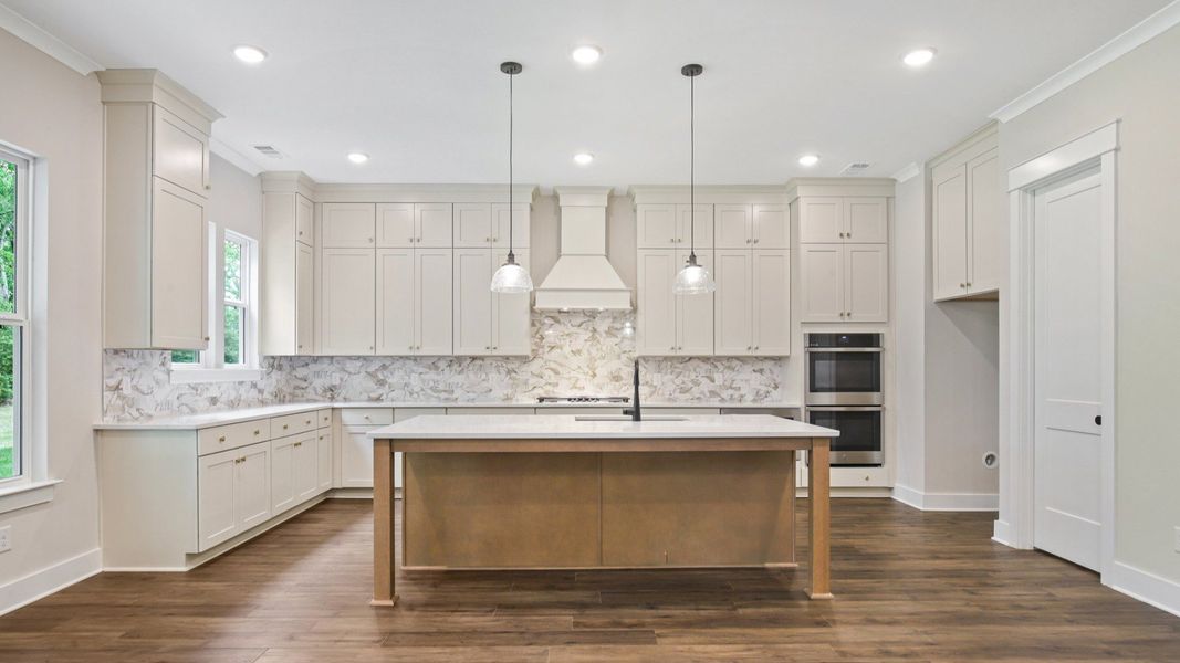 Kitchen with quartz countertops, tile backsplash, and pendant lighting Kitchen with quartz countertops, tile backsplash, and pendant lighting