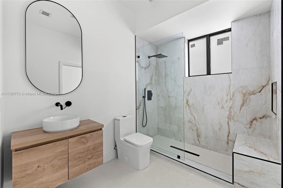 Finished with exquisite Taj Mahal Quartzite, the secondary bathroom offers a spacious shower with a premium rainfall showerhead, delivering comfort and style. Finished with exquisite Taj Mahal Quartzite, the secondary bathroom offers a spacious shower with a premium rainfall showerhead, delivering comfort and style.