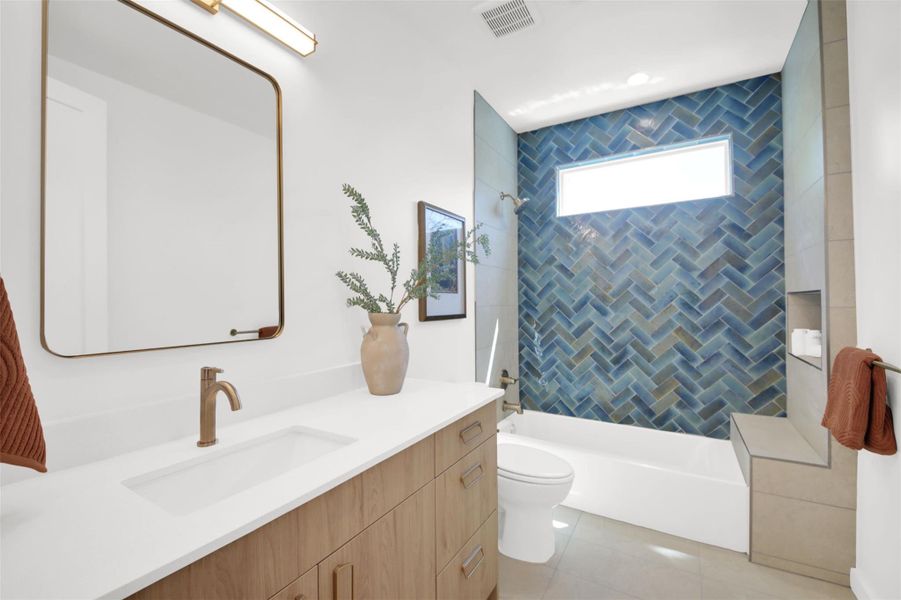 Bathroom featuring vanity, shower / tub combination, and light tile patterned floors