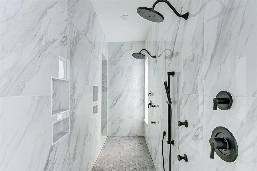 The massive walk-in shower features dual shower heads, a body shower head, and several built-in inserts. The marble-look tile surround, upgraded tile flooring, window and disk lights make this a true spa experience!