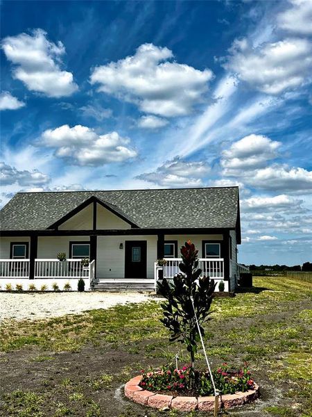 Rear view of property featuring covered porch and a shingled roof Rear view of property featuring covered porch and a shingled roof