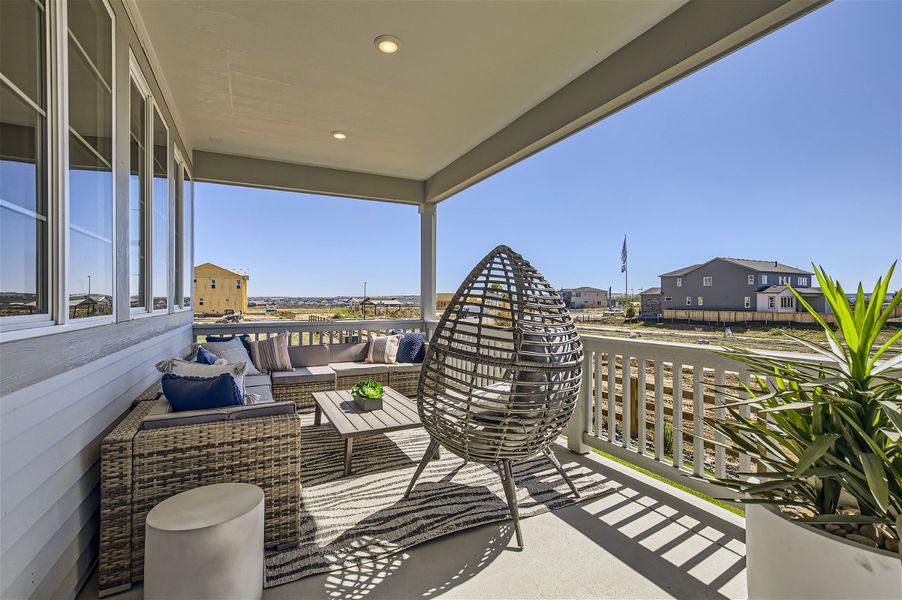 A patio with a chair and a table and chairs on it. A patio with a chair and a table and chairs on it.